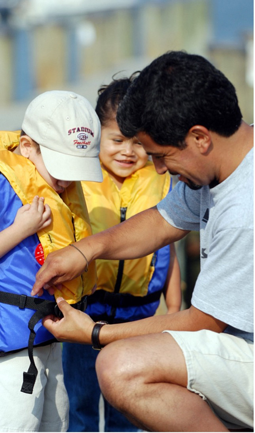 man fitting kids with life jackets
