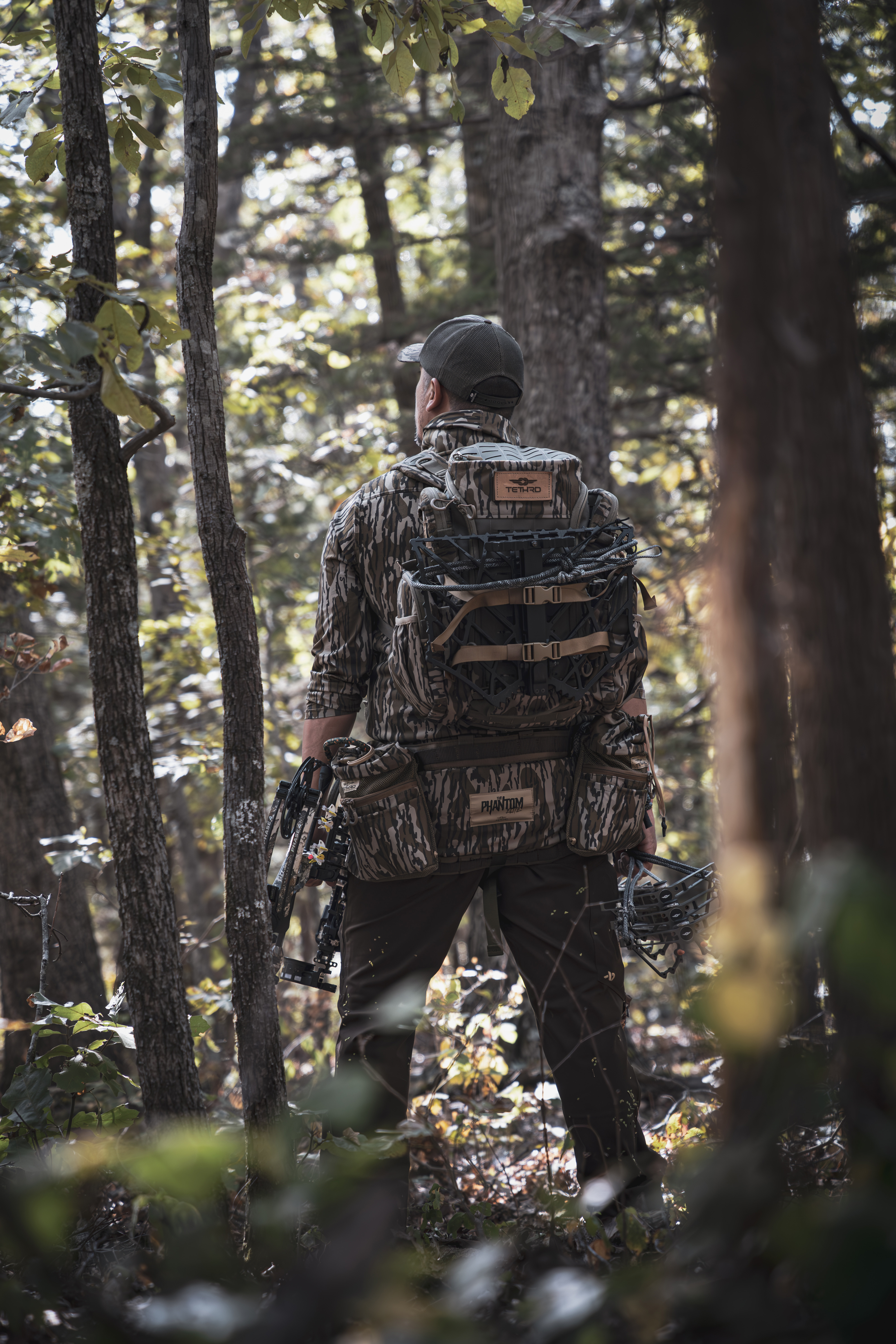 back of hunter with saddle equipment in woods